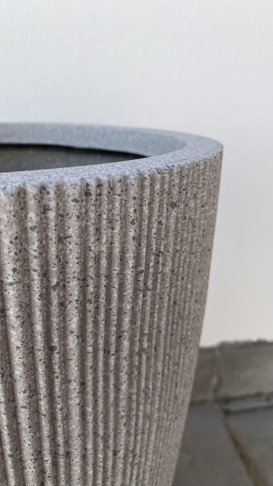 Vaso cilíndrico cinzento com textura riscada verticalmente
