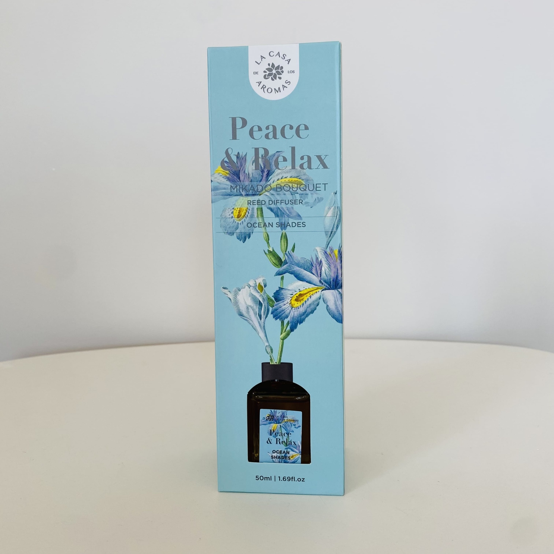 Embalagem azul clara com difusor de aromas e ilustração floral