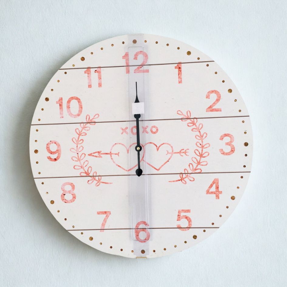 Relógio de parede redondo branco com números vermelhos e corações desenhados