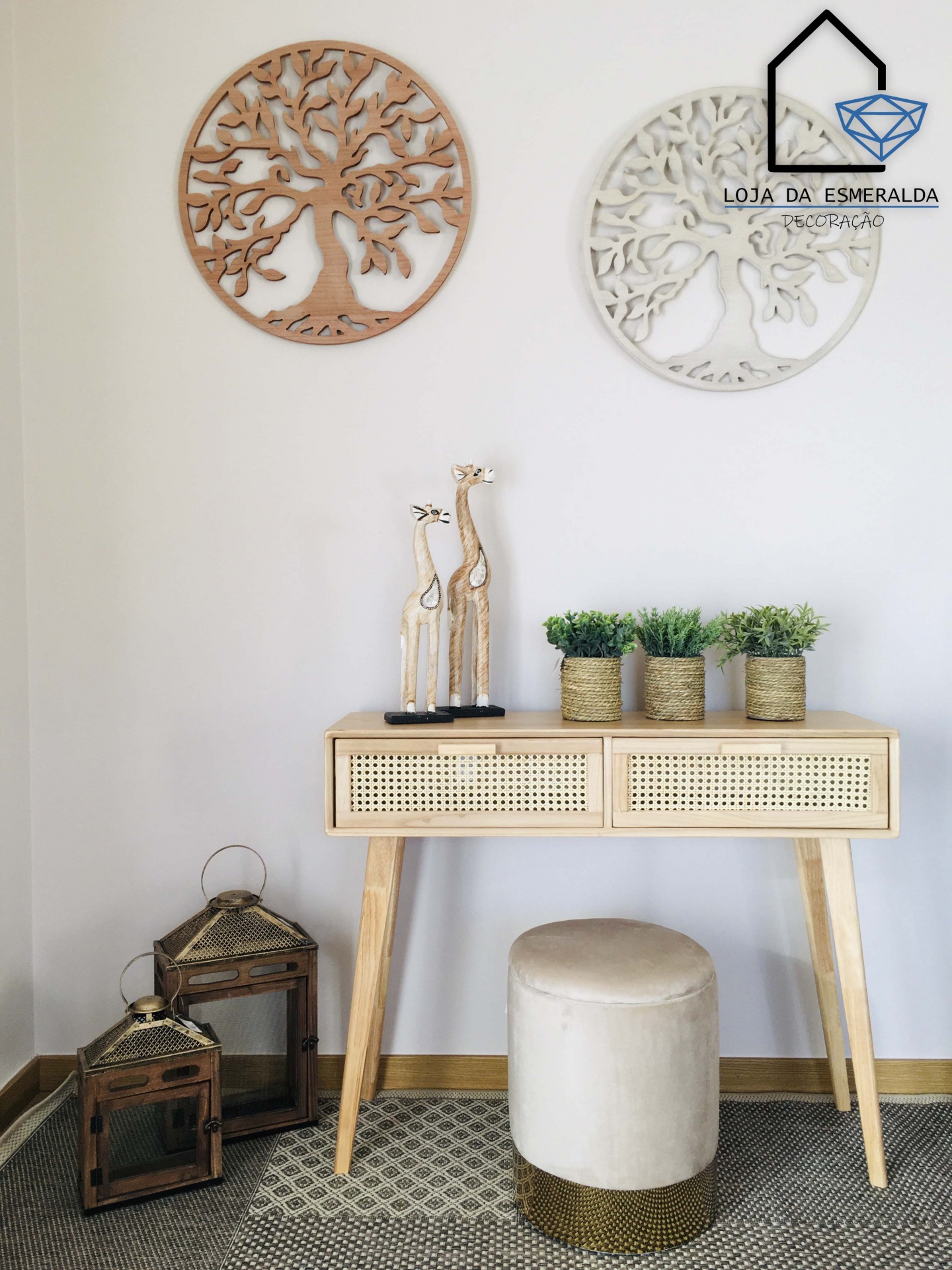 Conjunto de móvel em madeira clara com decoração de plantas, esculturas, lanternas e decorações de parede em formato de árvore.