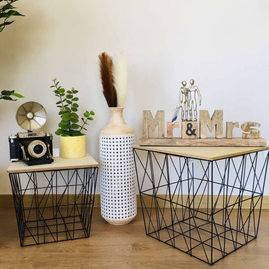 Duas mesas laterais com decoração variada, incluindo câmera antiga, vasos e enfeite Mr & Mrs