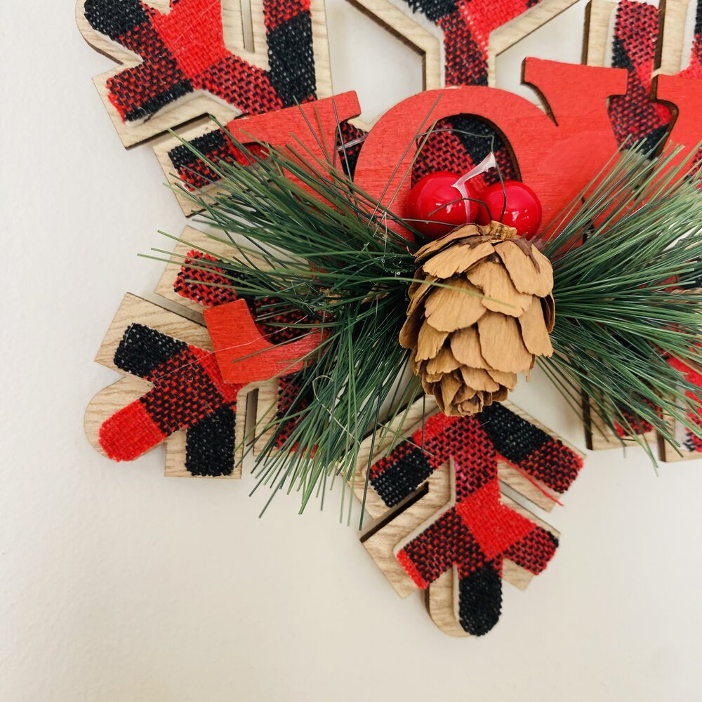 Enfeite natalício decorativo com floco de neve de madeira, padrão xadrez, folhas de pinheiro e bagas vermelhas