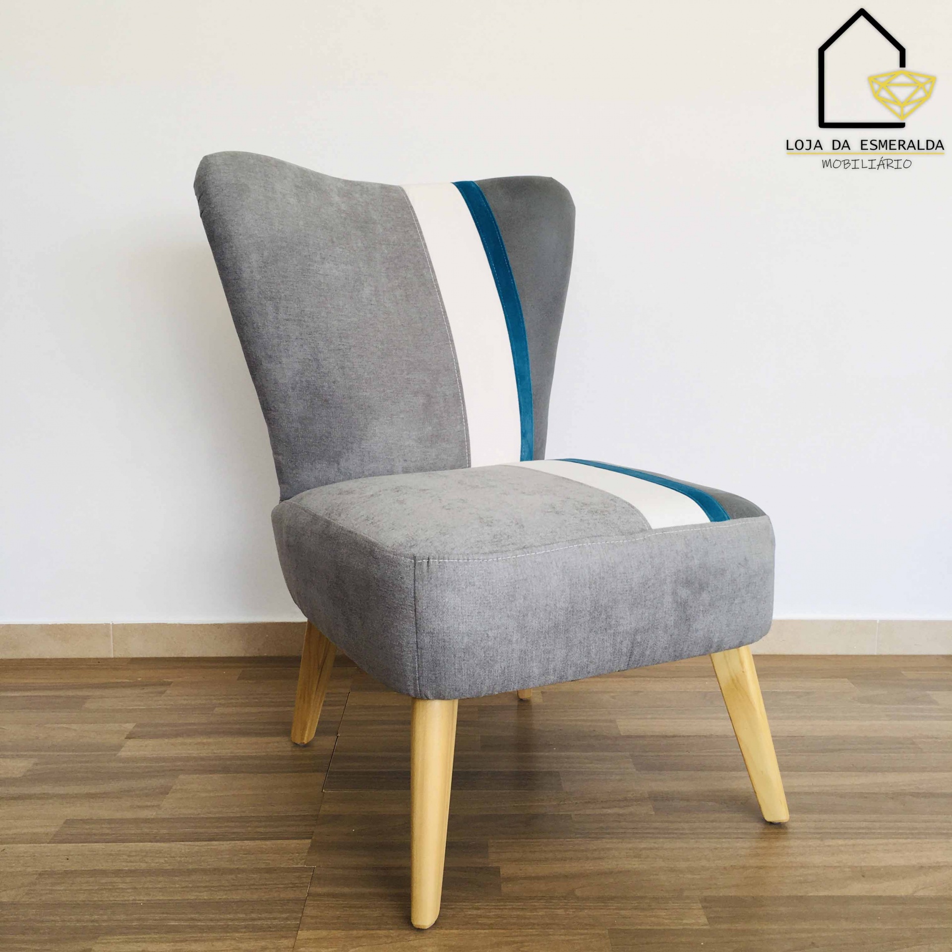 Cadeira cinzenta estofada com faixas coloridas e pernas em madeira clara