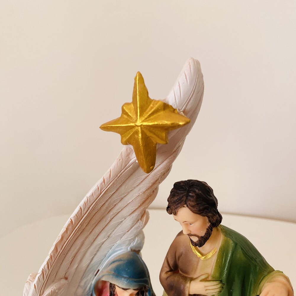 Estatueta de presépio com Maria, José, estrela dourada e estrutura branca