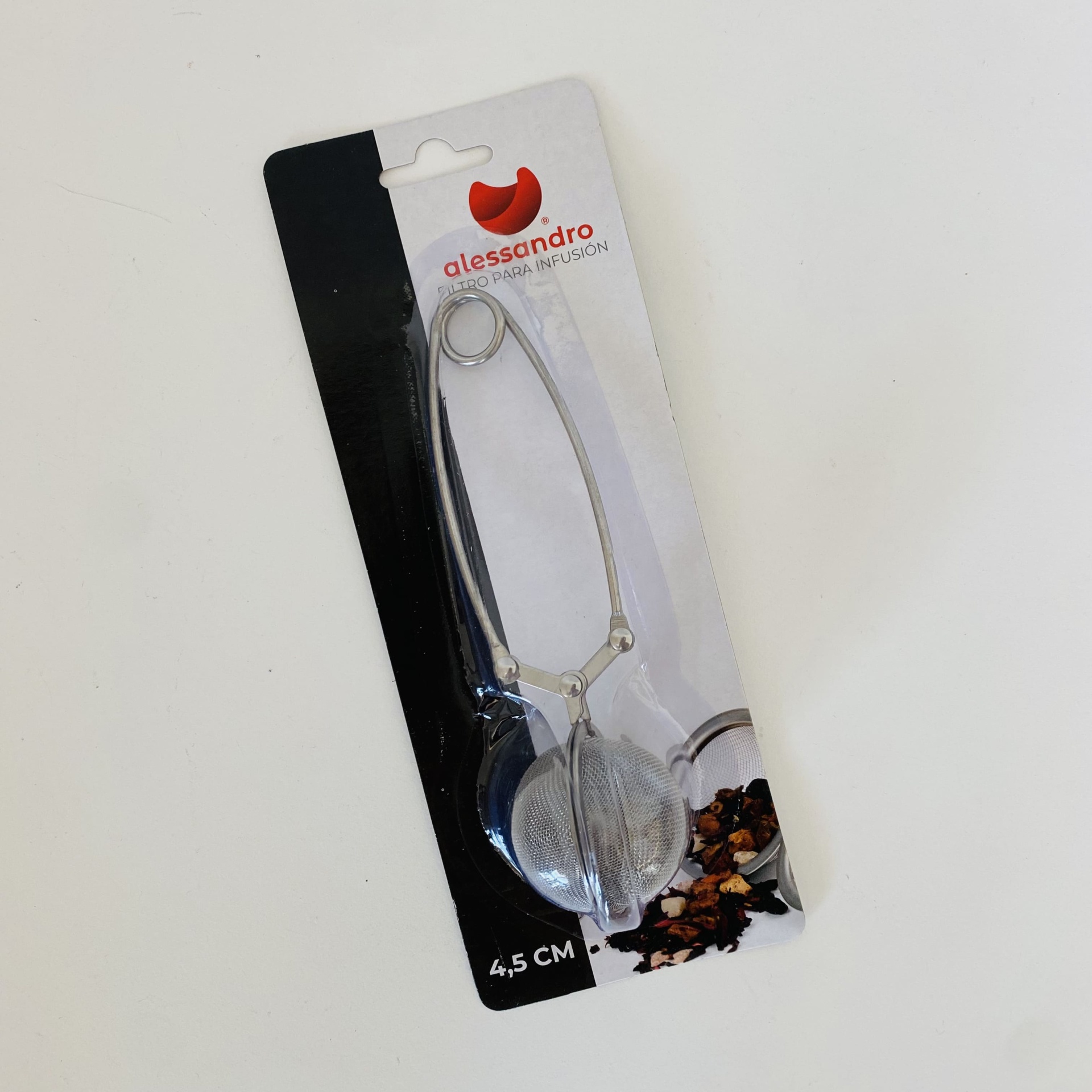 Infusor de chá metálico com malha fina em embalagem preta e branca.