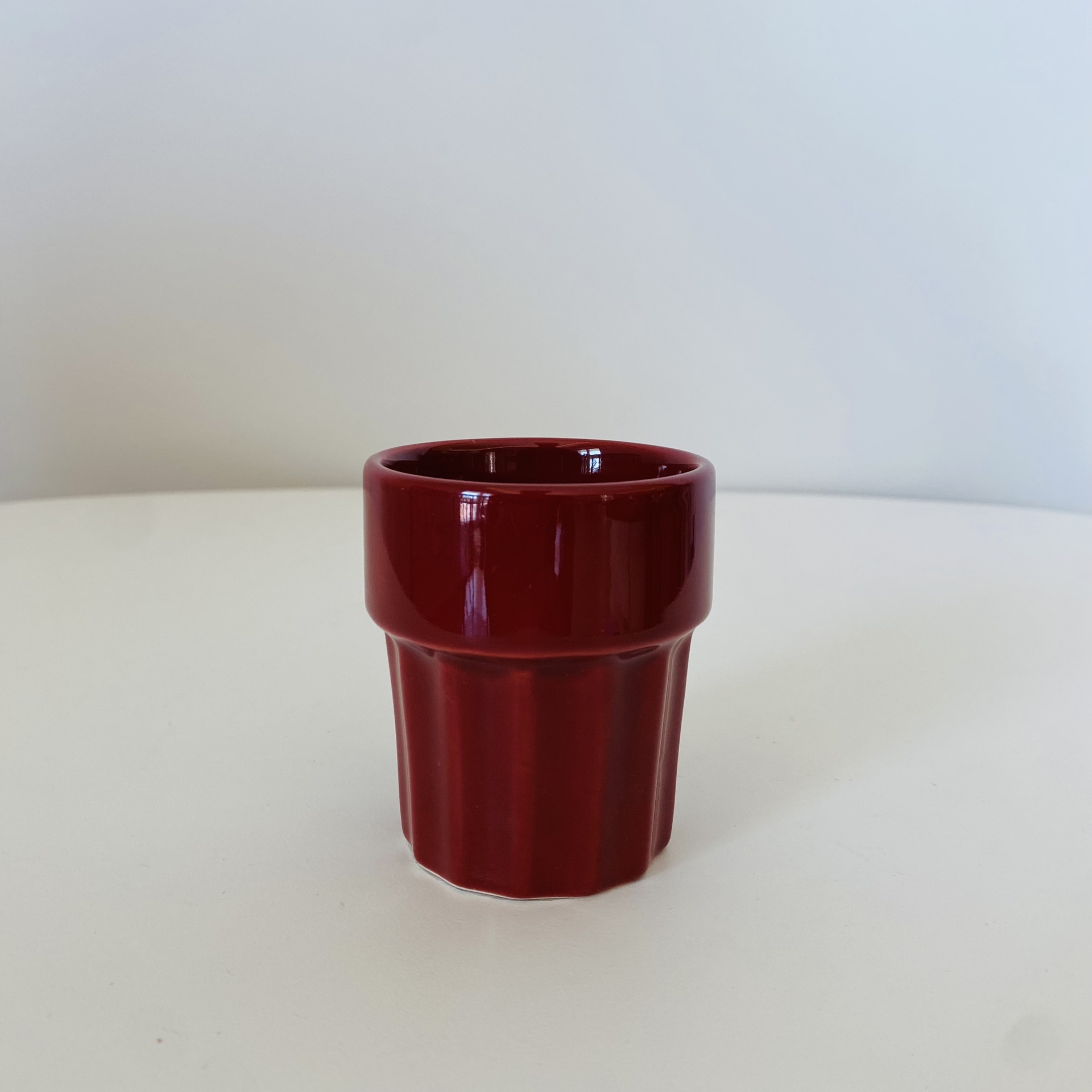 Copo pequeno de cerâmica vermelha com acabamento brilhante