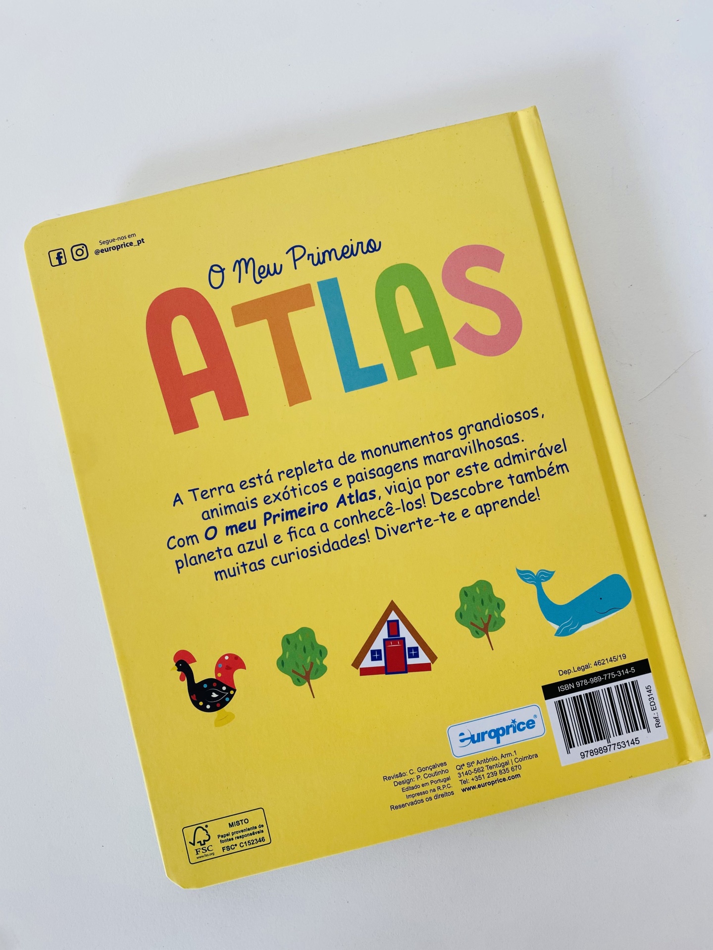 Livro infantil 'O Meu Primeiro ATLAS' com capa dura amarela e ilustrações coloridas na contracapa.