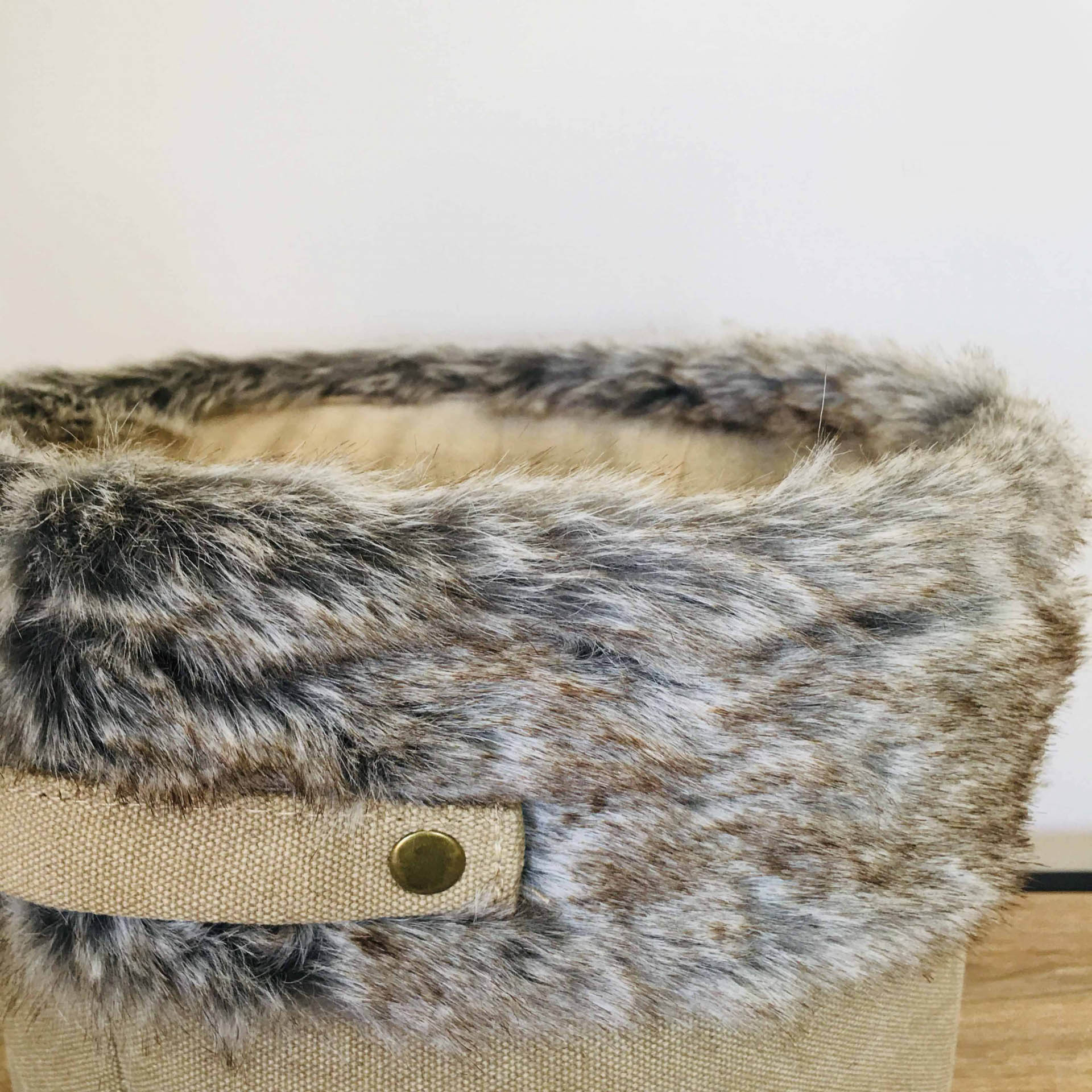 Cesto de armazenamento com tecido bege e pelo sintético cinzento e castanho com alça metálica