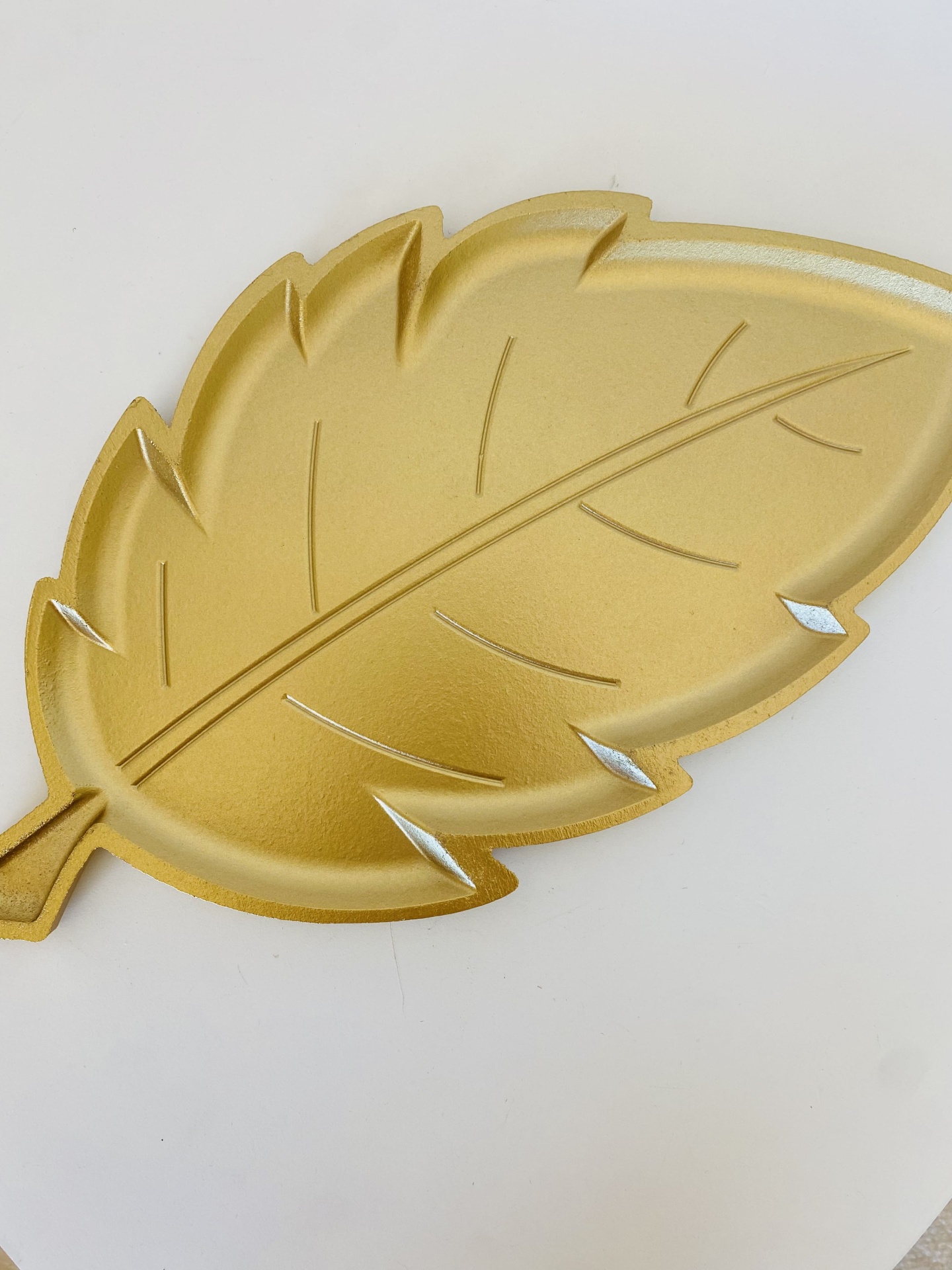 Prato decorativo dourado em forma de folha com textura