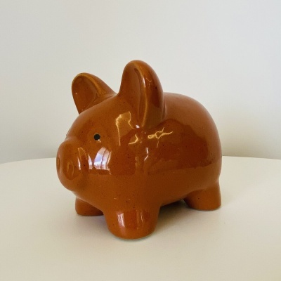 Cofre porquinho cerâmica castanho sobre superfície branca