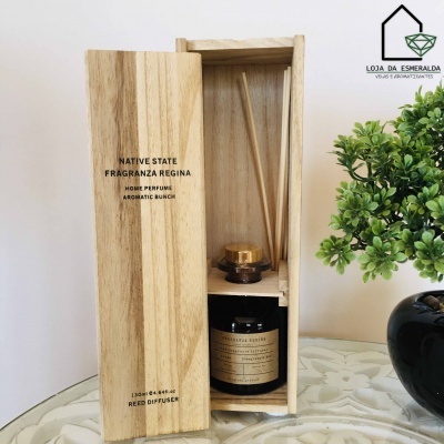 Difusor de varetas em caixa de madeira com planta verde em vaso preto