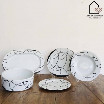 Conjunto de loiça branca com padrão de linhas pretas e logótipo da loja no canto superior direito