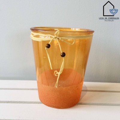 Vaso de vidro laranja com corda e contas em superfície branca