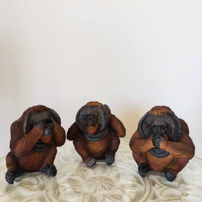 Três estatuetas de macacos em resina castanho-preto a representar os três macacos sábios