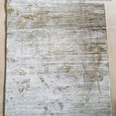 Tapete retangular cinza claro e bege com padrão abstrato colocado sobre chão de azulejos claros