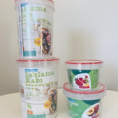 recipientes de plástico transparentes com tampas vermelhas e rótulos com imagens de frutas