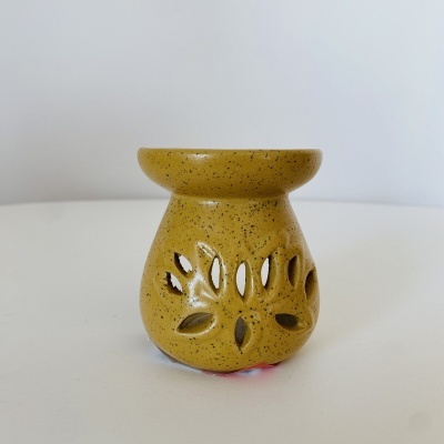 Recipiente de cerâmica amarelo com recortes em forma de folhas