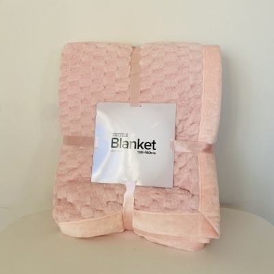 Cobertor rosa claro com etiqueta 'Winter Blanket 130x150cm' dobrado em mesa clara