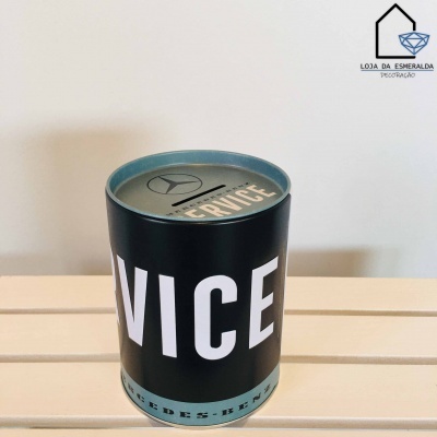 Vela aromática em lata preta e azul com texto e logótipo Mercedes-Benz numa mesa de madeira clara