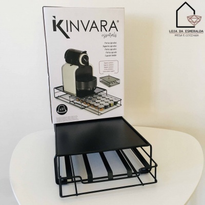 Suporte preto para máquina de café com gaveta para cápsulas em caixa sobre mesa branca.