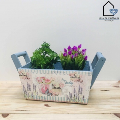 Jardineira decorativa azul claro com padrão floral e plantas artificiais