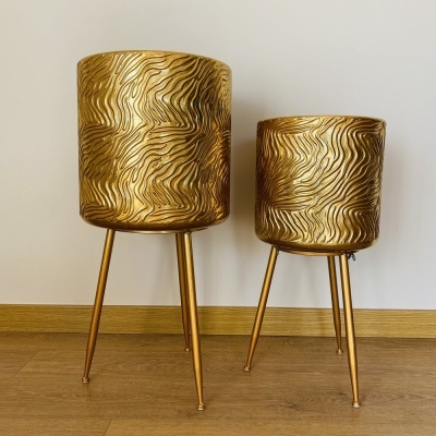 Dois suportes decorativos dourados para plantas com padrões ondulados