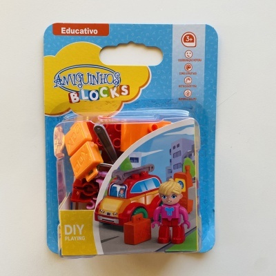 Brinquedo educativo Amiguinhos Blocks com peças de construção coloridas e figura humana em embalagem azul e amarelo.