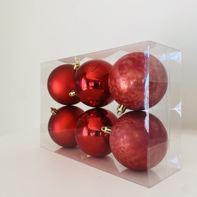 Caixa transparente com seis bolas de Natal vermelhas de diferentes acabamentos