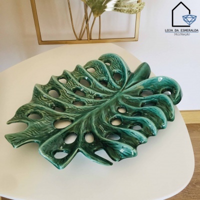 Prato decorativo cerâmico verde formato folha sobre mesa branca