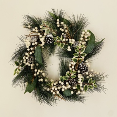 Guirlanda decorativa com folhas verdes, bagas brancas e pinhas brancas