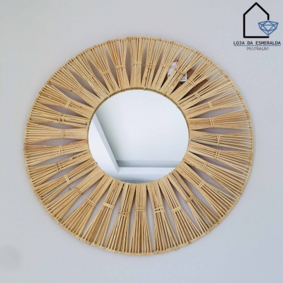 Espelho redondo com moldura de vime natural em parede branca