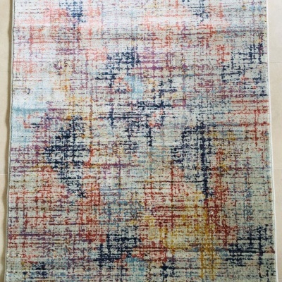 Tapete abstrato com várias cores sobre piso de azulejos claros