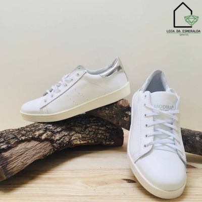 Sapatilhas brancas com pormenores prateados em fundo neutro com logótipo Loja da Esmeralda