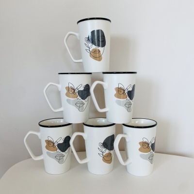 Seis canecas brancas com padrão abstrato preto e bege empilhadas em pirâmide