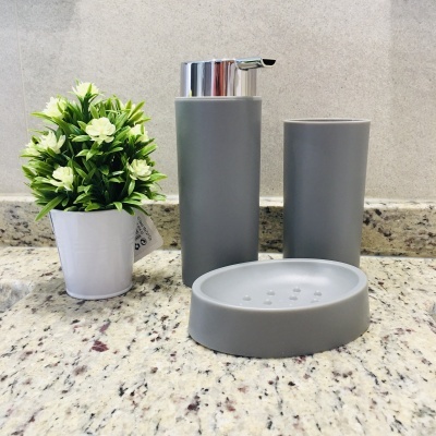 Conjunto de acessórios de casa de banho cinza com vaso de planta artificial branco sobre bancada de granito