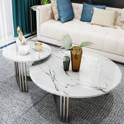 Mesa de centro dupla branca com padrão mármore e decoração sobre tapete cinza em sala moderna