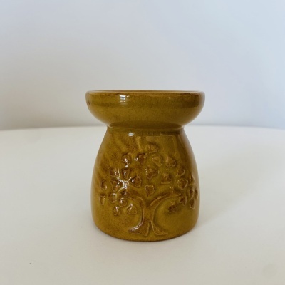 Vela de cerâmica castanha com relevo de árvore