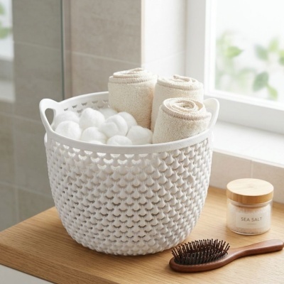 Cesto branco com toalhas e bolas de algodão sobre bancada de madeira