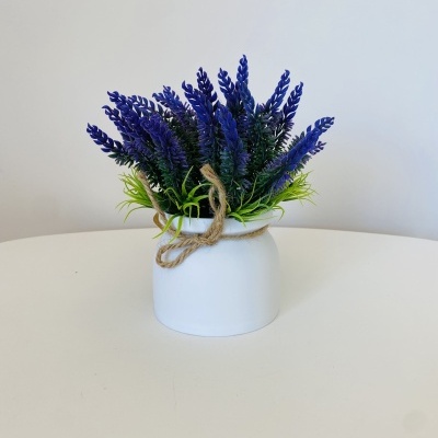 Arranjo decorativo de flores artificiais num vaso branco com corda