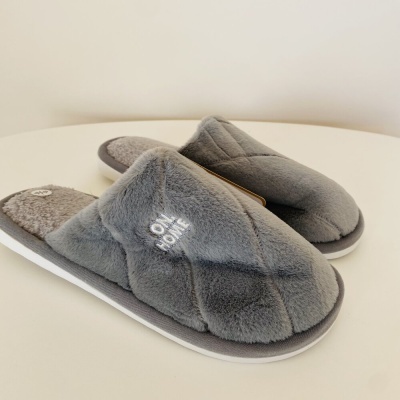 Pantufas cinzentas felpudas com texto branco 'ONE HOME'