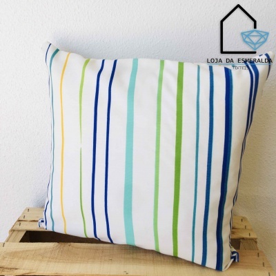 Almofada com riscas coloridas sobre caixa de madeira