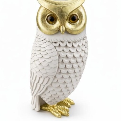 Estátua de coruja branca com detalhes dourados