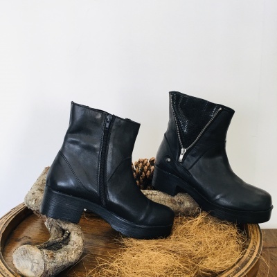 Botas pretas de cano médio com zíper em fundo branco