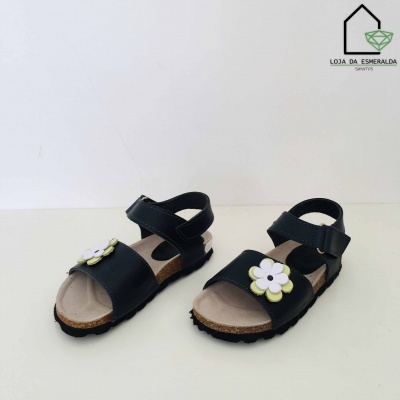 Sandálias infantis pretas com flor branca e amarela em fundo branco
