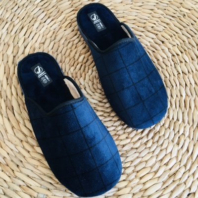 Chinelos de casa azuis escuros com padrão quadriculado sobre tapete de fibra trançada