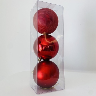 Três bolas de Natal vermelhas em embalagem transparente