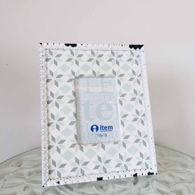 Moldura fotográfica geométrica cinza e branca sobre mesa de vidro