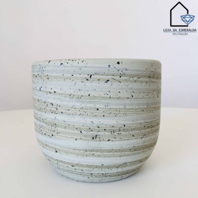 Vaso cerâmico listrado branco e cinza com manchas pretas em fundo branco.