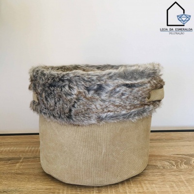 Cesto bege com aba de pelúcia cinzenta sobre superfície de madeira
