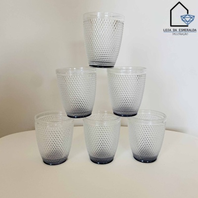 Conjunto de seis copos de vidro texturizados transparents com base azul escuro.